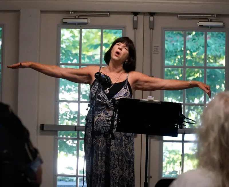 Performer singing with arms outstretched
