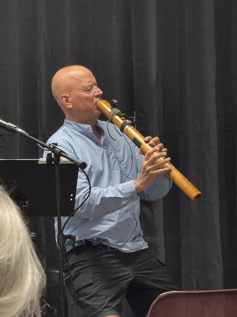 Musician playing flute at the Open Mic